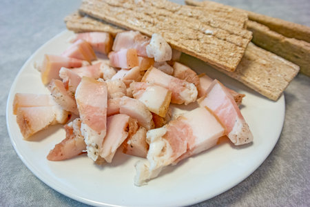 View of Traditional Sliced Salo Served With Dried Slices of Bread Top view Against Rustic Wooden Table Background. Horizontal Shotの写真素材