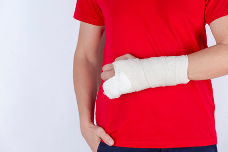 One Man in Red Shirt with Broken Hand In Plaster and Bandaid Holding Hands Straight Isolated on...