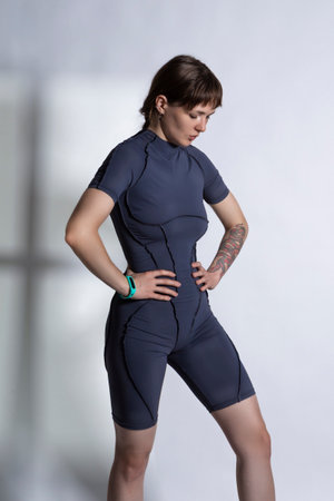 Calm Sportive Caucasian Female During Legs and Torso Musles Body Stretching Exercises in Blue...