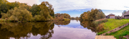 Tiny Wooden Pier and Line of Wooden Houses Places Together in Dukora Estate in Belarus. Panorama Imageの写真素材