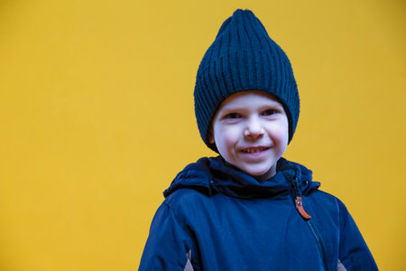 Portrait of Cute Caucasian Little Boy Smiling at Camera Posing Over Yellow Background Making. Horizontal Imageの写真素材