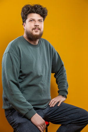 Young Caucasian Tranquil Brunette Handsome Man in Green Shirt Sweatshirt As Casual Clothes Looking...