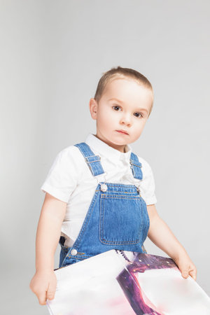 Little Male Kid Boy Of 2-3 Years Old Wearing Jeans Jacket White Shirt Isolated on Plain White Background As Children Indoor Studio Portrait To Convey Childhood Concept. Vertical Imageの写真素材