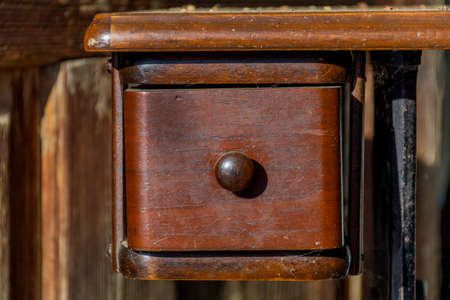 Detail of old wooden furniture with drawer. Vintage oak table closeup shot.の写真素材