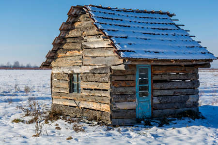 Landscape of old abandoned farm house covered with snow in a frosty winter. Old broken house in winter season.の写真素材