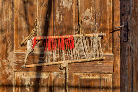 Detail of old traditional weaving loom and shuttle on the warp. Weaving loom for homemade on vintage background.の写真素材