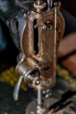 Defocused antique sewing machine head background. Close-up of old sewing machine foot.の写真素材