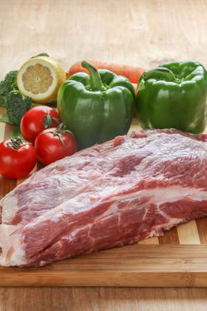 Raw pork and Vegetables on a cutting boardの写真素材