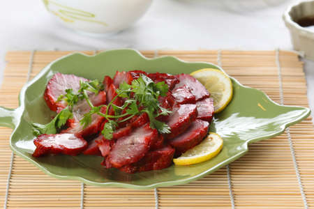 close up a dish of roast park on bamboo matの写真素材