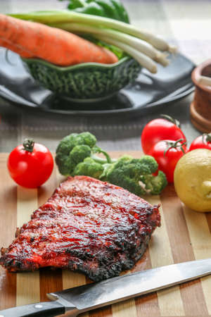 A slab Chinese Barbecue spare ribs on the cutting board with vegetable back groundの写真素材