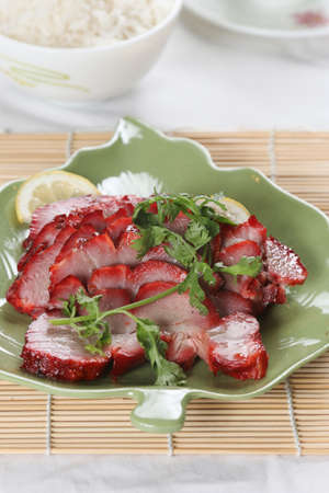 close up a dish of roast park on bamboo matの写真素材
