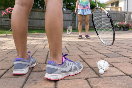 two girls palying badminton in their backyardの写真素材