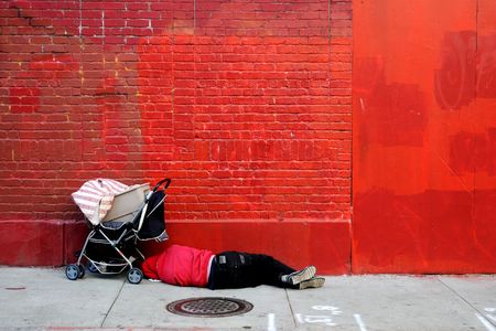 Man sleeping in front of red wallの写真素材