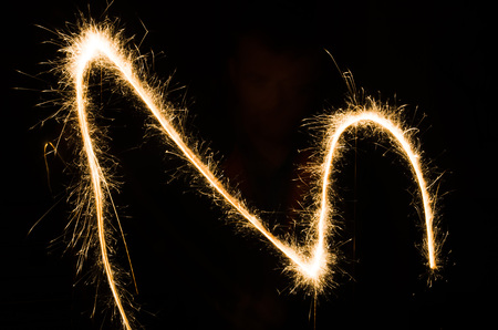 sparkler light trail in dark environment using slow shutter speedの写真素材