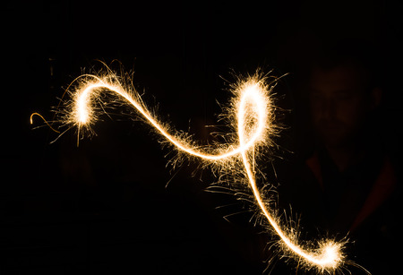 sparkler light trail in dark environment using slow shutter speedの写真素材