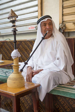 local man smoking shisha early in the morning at a cafeのeditorial素材