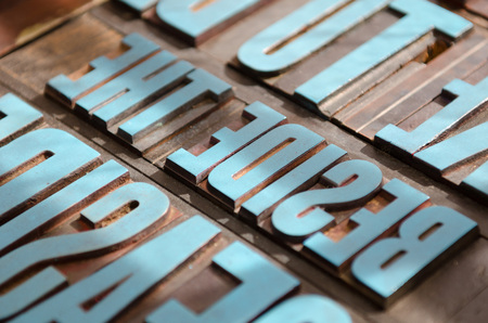 typeset letter blocks with blue paintの写真素材