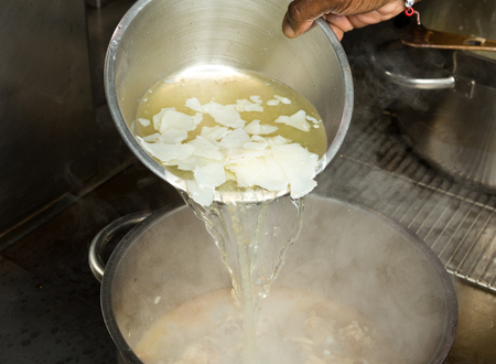ice Cold fresh organic chicken stock being poured onto hot chicken wings.の写真素材