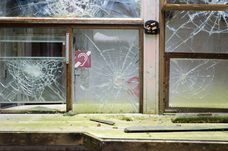 An old abandoned bank cashiers desk, with smashed glass windows, in an abandoned bank building. Exploring urban decay.のeditorial素材