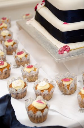 Beautiful inviting Sponge and cream cup cakes with a shallow depth of field, photographed on a table.の写真素材