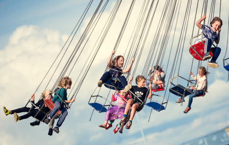 london, england, 05/05/2017 Children swinging in the air on a chair swing ride carousel, swing carousel. Children having fun on a fairground ride.のeditorial素材
