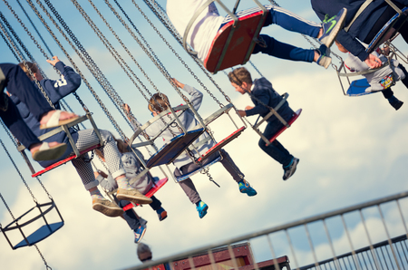 london, england, 05/05/2017 Children swinging in the air on a chair swing ride carousel, swing carousel. Children having fun on a fairground ride.のeditorial素材
