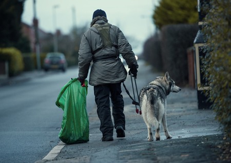 Wayne dixon and koda the Northern Inuit Dog walking around england cleaning up Street litter and fly tipping on the streets for charity. Wayne is raising money for the mental health charity MIND.の写真素材