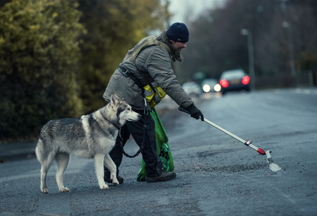 lancashire, England, 05/05/2017, Wayne dixon and koda the Northern Inuit Dog walking around england cleaning up Street litter and fly tipping on the streets for charity. Wayne is raising money for the mental health charity MIND.のeditorial素材