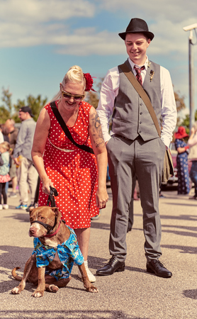 london, England, 05/05/2017, A stylish retro vintage fashionable couple with a Staffordshire bull terrier in a Hawaiian shirt at a Best dressed award at a vintage event. dogs in uniform.のeditorial素材