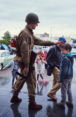 london, England, 05/05/2017, A stylish retro vintage world war two ww2 war veteran in soldier fancy dress uniform with a machine gun weapon. Best dressed award at a vintage nostalgic 1940's event. のeditorial素材