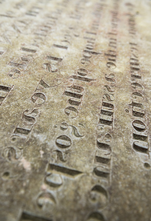 Grungy Abstract Hand carved typeset on an old english gravestone, with a shallow depth of fieldの写真素材