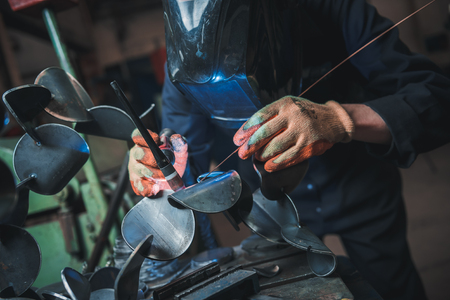 london, england, 02/02/2018 A vibrant action shot of a skilled working metal welder in action, welding metal. Photographed with a slow shutter speed and spark trails. Orange and teal.のeditorial素材