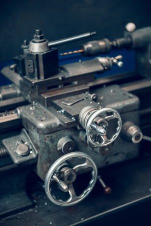 Beautiful matte silver metal industrial machinery steel cog handles in a rustic industrial factory setting. Well used processing machinery parts.の写真素材