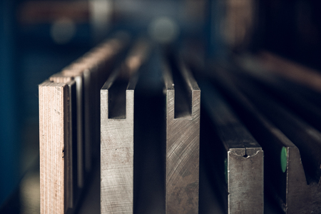 Vintage lead letterpress printing blocks against a weathered metal drawer background with bokeh.の写真素材
