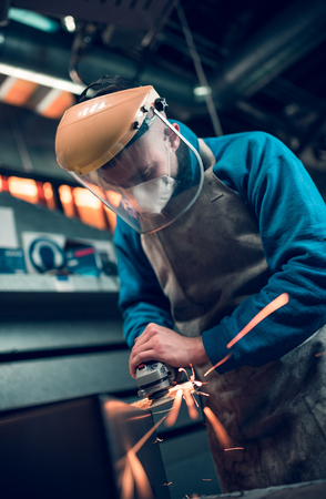 london, england, 02/02/2018, Young industrial metal working apprentice worker angle griding,learning various metal working skills in an industrial factory setting. Apprentice schemes returning to england.のeditorial素材