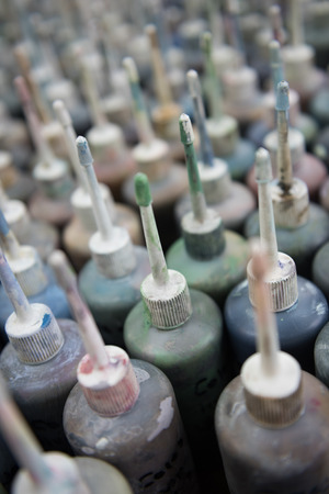 Industrial fabric and wallpaper dye ink paint, in plastic bottles with nozzles. Fabric dye is used in creating colour for the clothing and textile industry. fashion industry. Muted colours.の写真素材