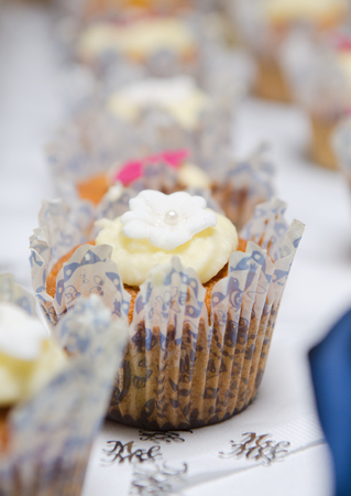 Beautiful inviting Sponge and cream cup cakes with a shallow depth of field, photographed on a table.の写真素材