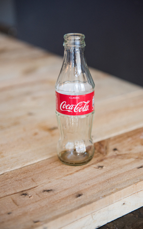 10/10/2018 An empty vintage glass coca cola coke bottle isolated against  s rustic background.のeditorial素材