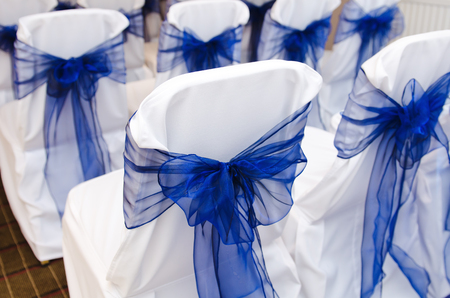gorgeous intricate wedding ceremony chair bow details on empty chairs in preparation for wedding ceremony.の写真素材
