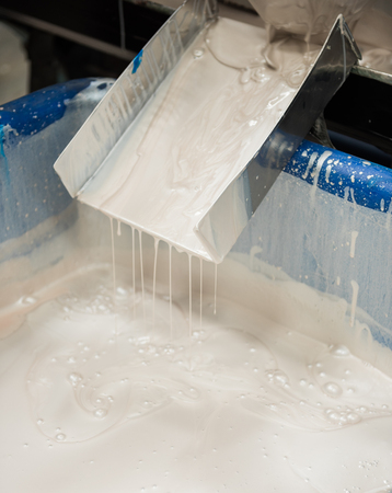 An industrial paint and colour mixing machine mixing paint in an industrial machine. paint sliding and dripping off a metal slide.の写真素材