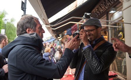 05/05/2017 A young arabic male tourist in london on the world famous carnaby street, looking and trying out retro film and movie cameras in an antique camera shop.のeditorial素材