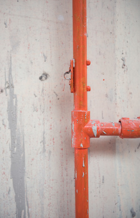 An orange Industrial metal water pipe a cold hard industrial factory setting. Metal iron pipes being...