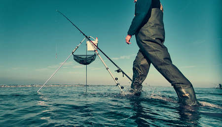 cleveleys, england, 01/01/2019 A beautiful cinematic scene of a fisherman fishing off the beach with a line and pole , with a dark blue aqua sky. Photography film colour grade.の写真素材