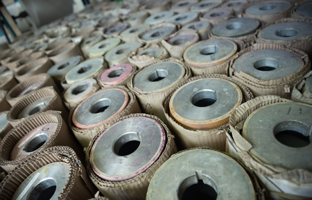 Beautiful metal industrial machinery steel cogs in a rustic industrial factory setting. Well used processing machinery parts.の写真素材