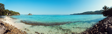 A stunning wide panoramic large format photograph of The stunning Anse royal beach in the seychelles, island of mahe. Paradise and beautiful blue sky.の写真素材