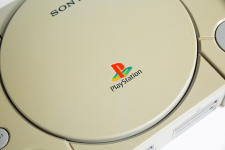 london, england, 07/05/2018 An original sony playstation console from 1994. PS1 retro video game console. old and discoloured vintage console. Sonys game hardware unit isolated on a white background.のeditorial素材