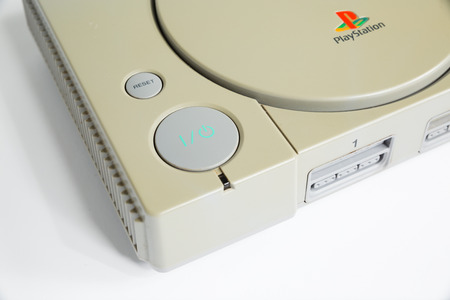 london, england, 07/05/2018 An original sony playstation console from 1994. PS1 retro video game console. old and discoloured vintage console. Sonys game hardware unit isolated on a white background.のeditorial素材