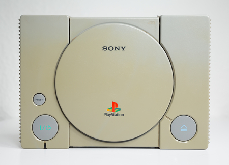 london, england, 07/05/2018 An original sony playstation console from 1994. PS1 retro video game console. old and discoloured vintage console. Sonys game hardware unit isolated on a white background.のeditorial素材