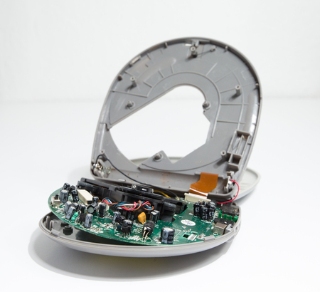 A broken old obsoleted personal portable cd player. exposed wires and circuit board. delicate technology. vintage and retro cd walkman with laser beam cd reader. plastic waste management and recycling.のeditorial素材