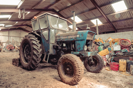 lancashire, England, 06/06/2016, An old abandoned vintage retro Ford tractor, forgotten and rusting in an old farm shed.のeditorial素材